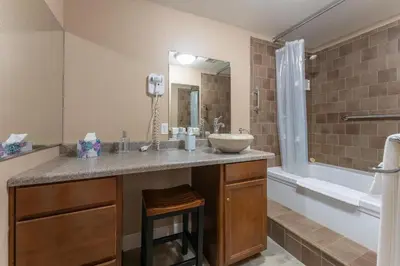 a bathroom with a sink and a tub at Big Creek Inn in Fish Camp