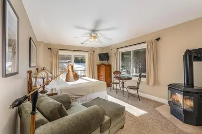 a living room with a bed and a fireplace at Big Creek Inn in Fish Camp
