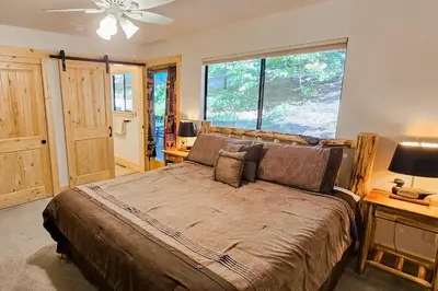 a bedroom with a large bed with a large window at Cabin In The Woods in Arnold