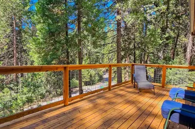 a wooden deck with chairs and trees at Cabin In The Woods in Arnold