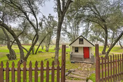 a small house with a red door behind a fence at Family Home Near Kings and Sequoia National Parks! in Squaw Valley