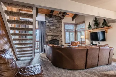 a living room with a large couch and a fireplace at Mammoth Creek Townhome # 40 Updated 2 bedrooms and Loft 2 and half bath Steps to free town shuttle stop in Mammoth Lakes