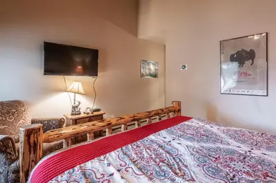 a bedroom with a bed and a flat screen tv at Mammoth Creek Townhome # 40 Updated 2 bedrooms and Loft 2 and half bath Steps to free town shuttle stop in Mammoth Lakes