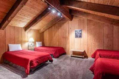 two red beds in a room with wooden walls at Mammoth Creek Townhome # 40 Updated 2 bedrooms and Loft 2 and half bath Steps to free town shuttle stop in Mammoth Lakes