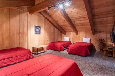 three beds in a room with wooden walls at Mammoth Creek Townhome # 40 Updated 2 bedrooms and Loft 2 and half bath Steps to free town shuttle stop in Mammoth Lakes