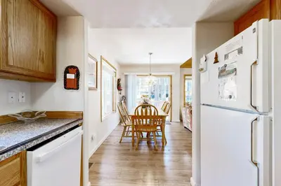 a kitchen with a white refrigerator and a table at Little Pinecone Retreat in Truckee