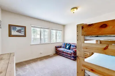 a bedroom with a bunk bed and a couch at Little Pinecone Retreat in Truckee