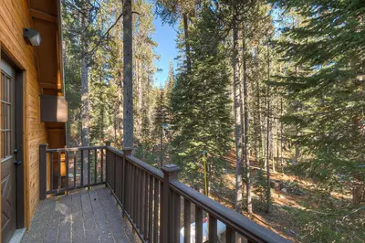 a balcony of a house with a view of the woods at The Truckee Vibe in Soda Springs