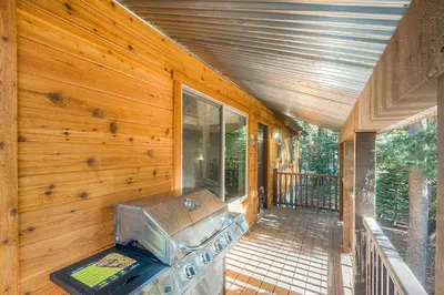 a porch of a house with a grill on it at The Truckee Vibe in Soda Springs