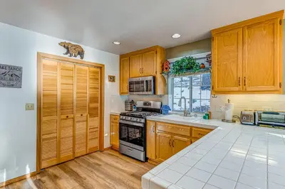 a kitchen with wooden cabinets and a stove top oven at Mountainside Retreat in Truckee