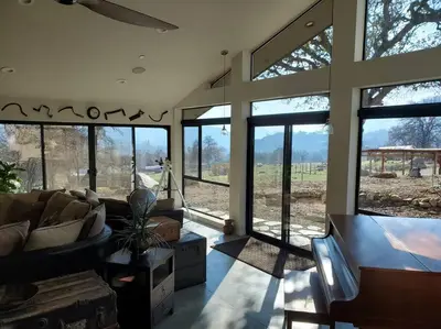a living room with large windows and a couch at Matanah Meadows Farm, Great for 2 Families, Sequoia National Park and Working Farm in Three Rivers