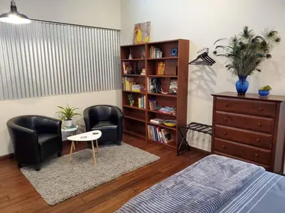 a bedroom with two chairs and a book shelf at Matanah Meadows Farm, Great for 2 Families, Sequoia National Park and Working Farm in Three Rivers