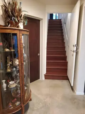 a hallway with a staircase and a glass cabinet at Matanah Meadows Farm, Great for 2 Families, Sequoia National Park and Working Farm in Three Rivers