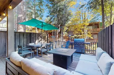 a patio with couches and a table and a grill at Peace Among the Pines in Incline Village