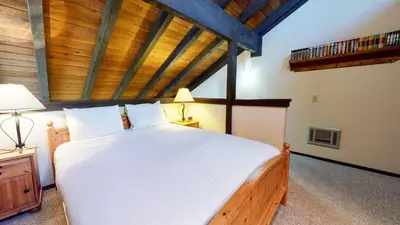 a bedroom with a large white bed with a wooden ceiling at La Vista Blanc #44 condo in Mammoth Lakes