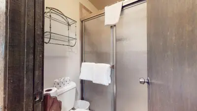 a bathroom with a shower with a toilet and a glass door at La Vista Blanc #44 condo in Mammoth Lakes