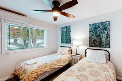 a bedroom with two beds and a ceiling fan at Starfall in Yosemite West