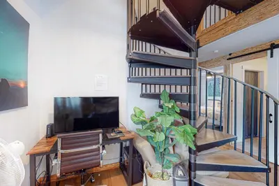 a spiral staircase in a room with a television and a plant at Starfall in Yosemite West