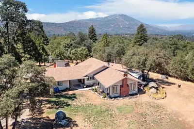 an aerial view of a house with mountains in the background at Bear Den in Oakhurst