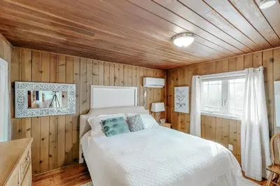 a bedroom with a bed and a wooden wall at Bear Den in Oakhurst