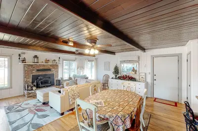 a living room with a table and a fireplace at Bear Den in Oakhurst