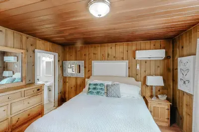 a bedroom with a bed and a wooden wall at Bear Den in Oakhurst