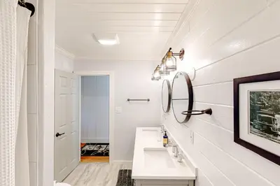 a white bathroom with a sink and a mirror at Bear Den in Oakhurst