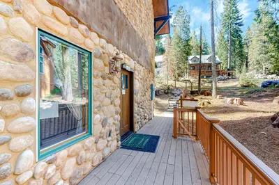 a stone building with a porch and a window at Oso Lodge Unit B in Yosemite West