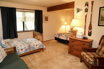 a bedroom with two beds and a couch and a chair at Forest Glen in Yosemite West