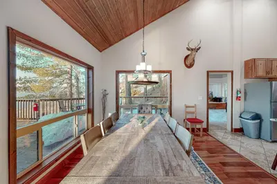 a large wooden table in a room with a large window at Glacier Peak Lodge in Yosemite West