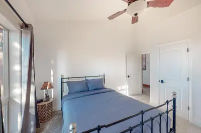 a bedroom with a blue bed and a ceiling fan at Glacier Peak Lodge in Yosemite West