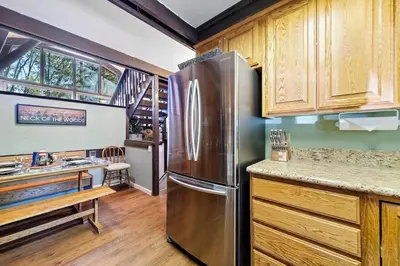 a kitchen with a stainless steel refrigerator and wooden cabinets at Chief Peak in Fish Camp