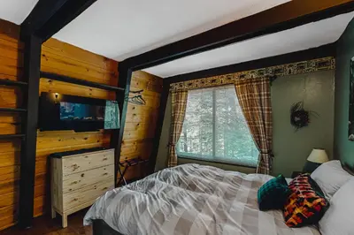 a bedroom with a bed and a large window at Chief Peak in Fish Camp
