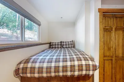 a small bed in a room with a window at A River Runs Through It in Incline Village