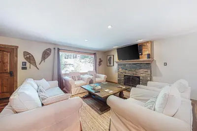 a living room with white furniture and a fireplace at A River Runs Through It in Incline Village