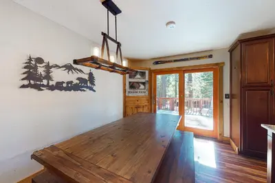 a dining room with a wooden table and a chandelier at A River Runs Through It in Incline Village