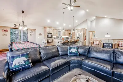 a living room with a black leather couch at Susquehana Luxury in South Lake Tahoe