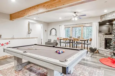 a pool table in a living room with a fireplace at Susquehana Luxury in South Lake Tahoe