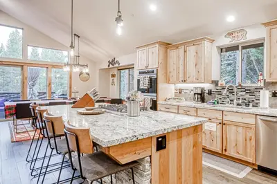 a kitchen with wooden cabinets and a large island with chairs at Susquehana Luxury in South Lake Tahoe