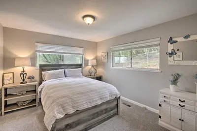 a bedroom with a large bed and two windows at Forest-View Deck and Fire Pits Pine Grove Retreat! in Jackson