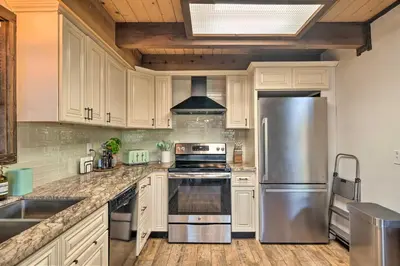 a kitchen with white cabinets and a stainless steel refrigerator at Near Trails Cabin with 2-Level Deck in Twain Harte in Twain Harte