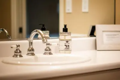 a bottle of soap sitting on a bathroom sink at Sierra Ranch - A Yosemite Retreat in Mariposa