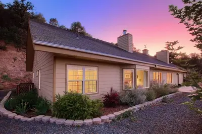 a small white house with a garden in front of it at Sierra Ranch - A Yosemite Retreat in Mariposa