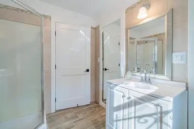 a white bathroom with a sink and a mirror at Plush 2-bed apt in Riverside Heights! in Reno