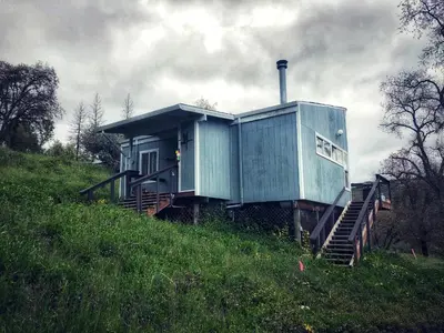 a house sitting on top of a grassy hill at Sequoia Resort in Badger