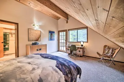 a bedroom with a large bed and a desk and windows at Deck and Fireplace Log Cabin in Tahoe Donner! in Truckee