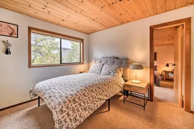 a bedroom with a bed and a window at Deck and Fireplace Log Cabin in Tahoe Donner! in Truckee