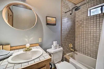 a bathroom with a sink and a toilet and a mirror at Deck and Fireplace Log Cabin in Tahoe Donner! in Truckee