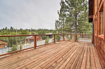 a large wooden deck with a view of trees at Deck and Fireplace Log Cabin in Tahoe Donner! in Truckee