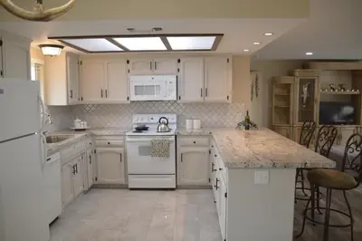 a kitchen with white cabinets and a white stove top oven at Beautiful 3 bedroom home located near Yosemite in Oakhurst